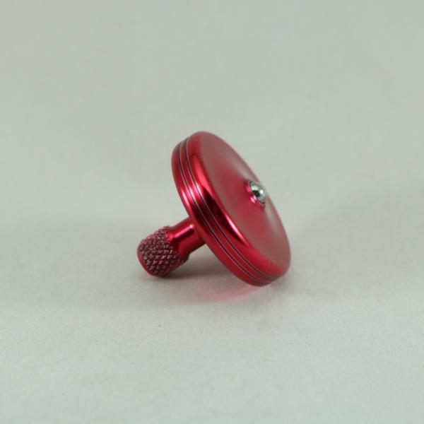 Side view of the S2 metal spinning top by Kemner Design in candy red aluminum