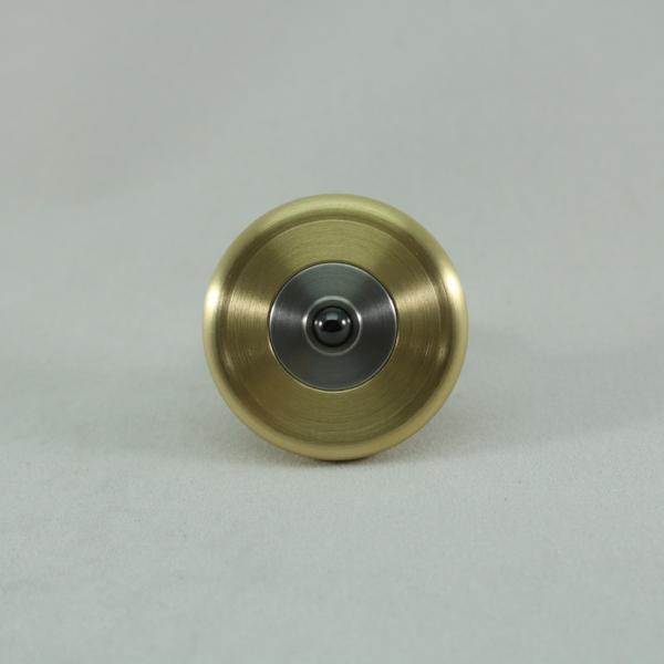 Bottom view of the M3 metal spinning top shown here in brushed brass and stainless steel with a ceramic bearing