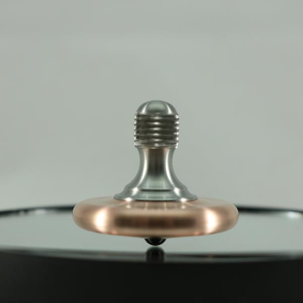 Beautiful M3 spinning top show here in brushed copper and stainless steel  caught mid-spin