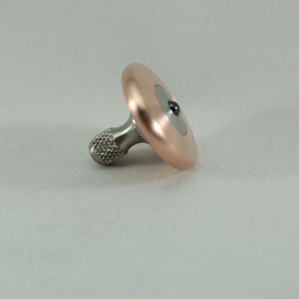Side view of the copper and titanium M3 precision spin top by Kemner Design