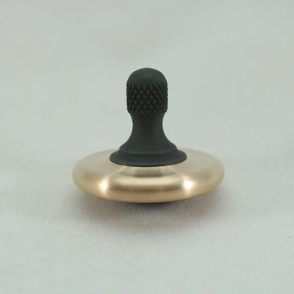 Focus on the knurl on this brushed bronze and blacked out stainless steel M3 spinning top by Kemner Design