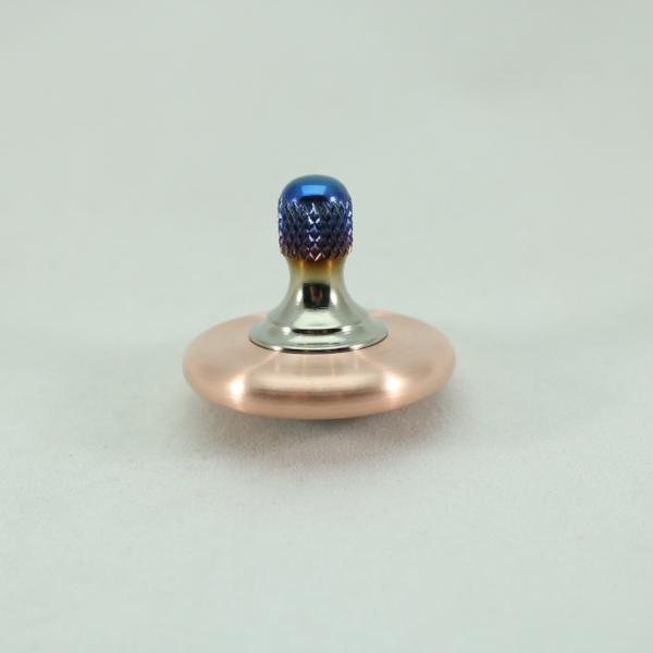 Brushed copper and blue flamed titanium top on the Kemner Design M3 precision metal spinning top