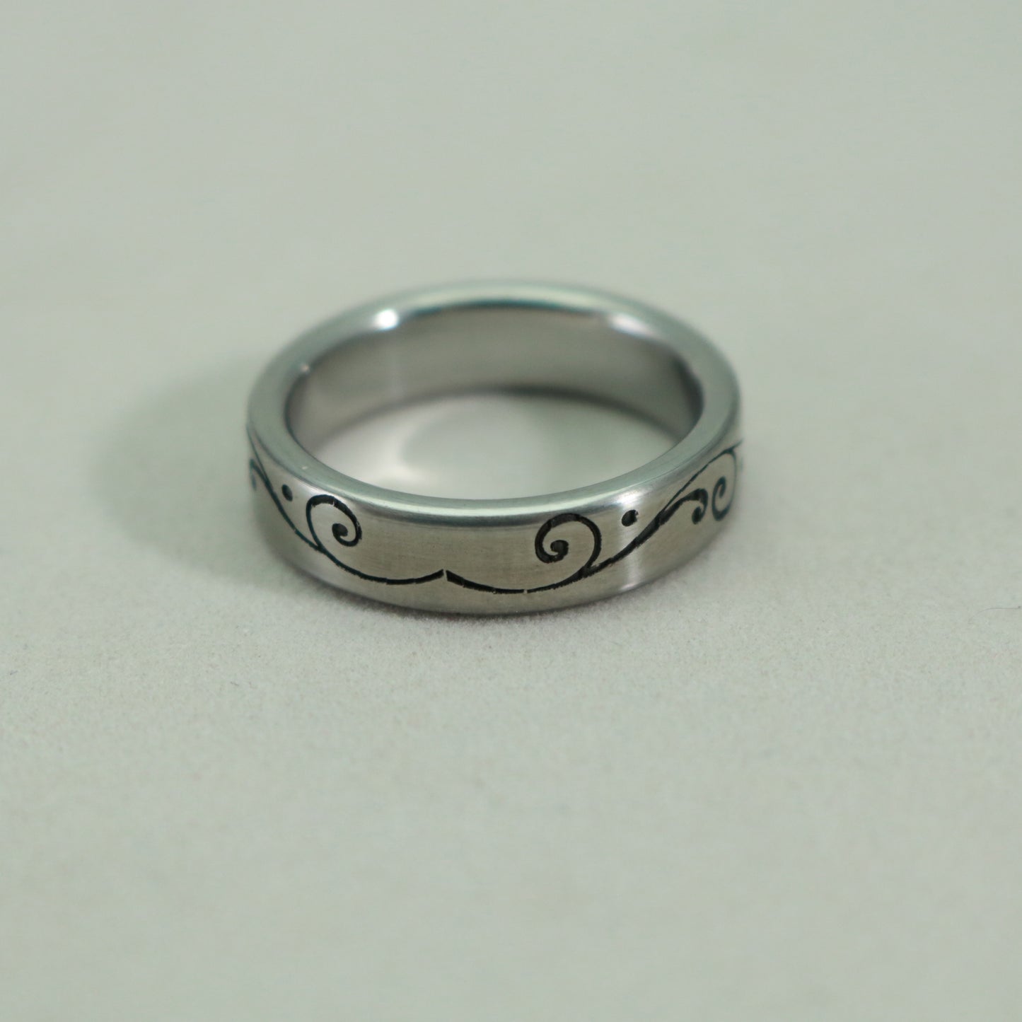 Stainless steel ring in size 7 1/4 with a laser engraved floral pattern