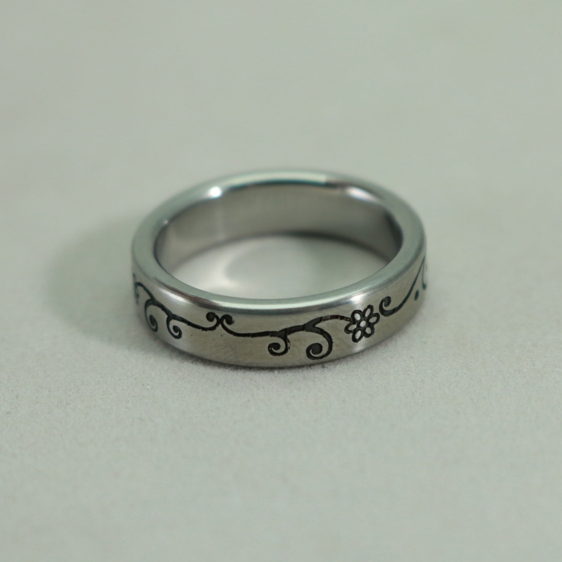 Band is .2 in wide in this lovely laser engraved stainless steel ring by Kemner Design
